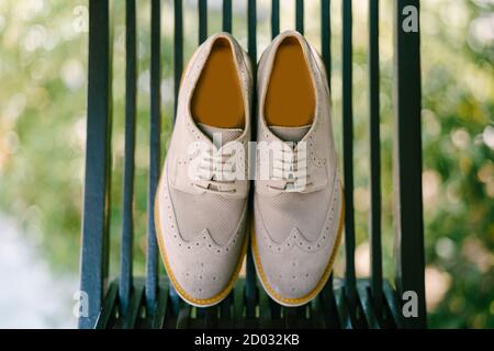 Close-up Gray men's oxford shoes on a wooden chair in the garden. Stock Photo