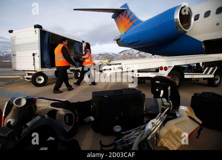 Baggage handlers unload a McDonnell Douglas MD-80 series passenger jet belonging to Allegiant Air at the Ogden-Hinckley Airport in Ogden, Utah, March 11, 2013. Picture taken March 11, 2013. REUTERS/Jim Urquhart (UNITED STATES - Tags: TRANSPORT BUSINESS)