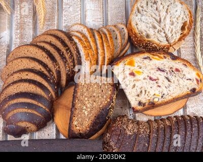 assortment of different freshly baked breads on wooden table Stock Photo