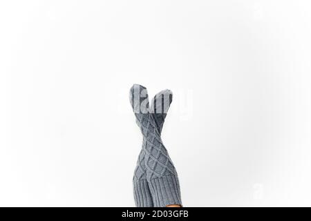 Gray knitted knee socks on the legs on a white background. Legs in long socks upside down. Hobby Stock Photo