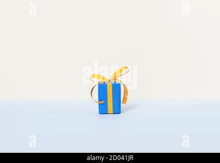 Blue gift box with yellow ribbon on a pastel background and space for your text Stock Photo