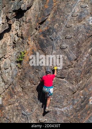 Woman climbs on the Ouray Via Ferrata, Ouray, Colorado. Stock Photo