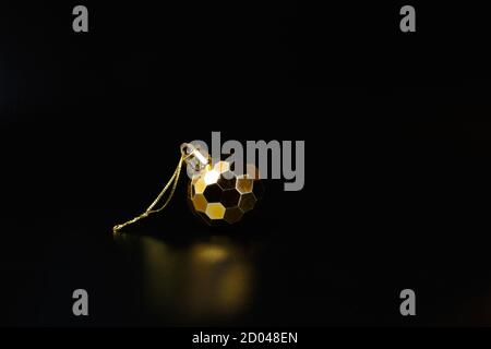 Golden Christmas tree bauble sphere on black. New Year tree decoration Stock Photo