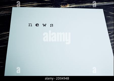 the word news stamped on a paper lying on wooden surface with copy space Stock Photo