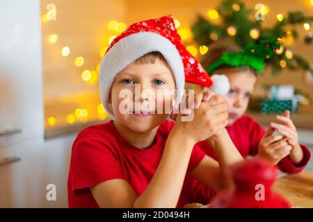 Happy children are preparing gingerbread on the eve of new year. Children make holiday cookies at home. Stock Photo