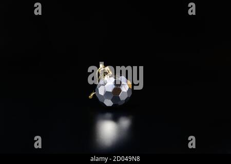 Silver colored New Year tree decoration. Christmas tree bauble sphere on black Stock Photo
