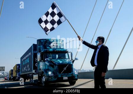 Long Beach, California, USA. 2nd Oct, 2020. Mayor of Long Beach ROBERT GARCIA wearing a face mask waves a checkered flag during the opening ceremony for the new Gerald Desmond Bridge in Port of Long Beach, Friday. The bridge will open to traffic on Monday by 5 a.m. Credit: Ringo Chiu/ZUMA Wire/Alamy Live News Stock Photo