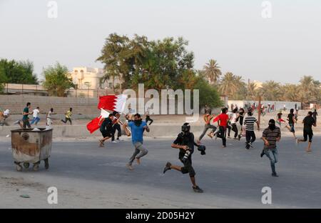 People run for cover as riot police charge to disperse an anti-government protest in the village of Shakhoora, west of Manama, August 14, 2013. Bahraini police fired tear gas and birdshot at demonstrators on Wednesday, witnesses said, as protests called for by activists to press demands for democratic change in the U.S.-allied Gulf kingdom turned violent. REUTERS/Hamad I Mohammed (BAHRAIN - Tags: POLITICS CIVIL UNREST)