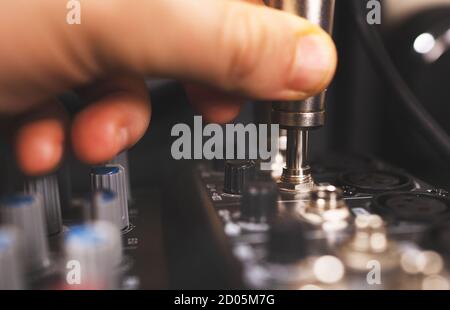 Sound engineer plugging jack audio cable on studio mixer. Stock Photo