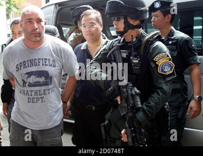 Thai policemen escort American drug suspect Joseph Hunter, 48, as he arrives at Don Mueang International Airport in Bangkok September 27, 2013. Thai police transferred six foreigners suspected of drug smuggling to Bangkok on Thursday after their arrests in the seaside resort, Phuket. Hunter, along with two British, a Taiwanese, a Slovak, and a Filipino were arrested on Phuket island on Wednesday following a tip-off from the United States Drug Enforcement Administration (DEA).   REUTERS/Chaiwat Subprasom (THAILAND - Tags: CRIME LAW DRUGS SOCIETY)