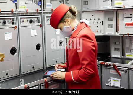 Vienna, Austria. 2nd Oct, 2020. A stewardess of Austrian Airlines works on a flight to Shanghai before takeoff at the Vienna International Airport in Schwechat, Austria, on Oct. 2, 2020. Austrian Airlines resumed passenger flights to Shanghai on Friday, which were suspended due to the COVID-19 pandemic. Credit: Georges Schneider/Xinhua/Alamy Live News Stock Photo