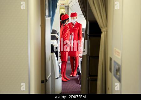 Vienna, Austria. 2nd Oct, 2020. Stewardesses of Austrian Airlines work on a flight to Shanghai before takeoff at the Vienna International Airport in Schwechat, Austria, on Oct. 2, 2020. Austrian Airlines resumed passenger flights to Shanghai on Friday, which were suspended due to the COVID-19 pandemic. Credit: Georges Schneider/Xinhua/Alamy Live News Stock Photo