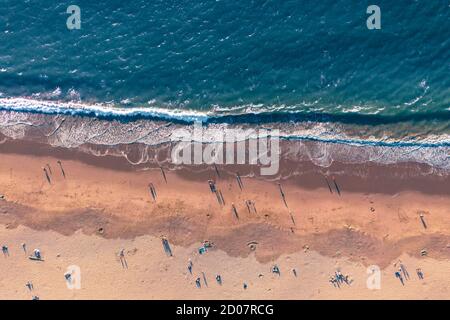 Aerial looking down view of people enjoying the beach at sunset in California, USA Stock Photo