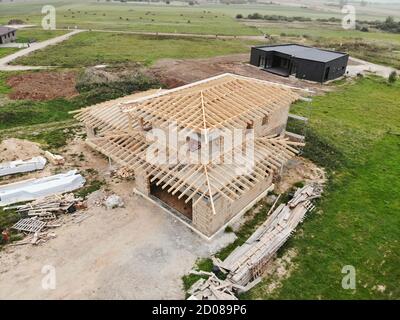 Aerial view of new house under construction at construction site. Roof construction in progress. Stock Photo