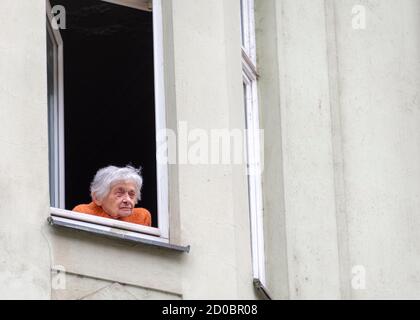 PRAGUE, CZECH REPUBLIC - OCTOBER 13, 2016: An elderly woman in the window of a house in the Josefov or Jewish Quarter of Prague, Czech Republic Stock Photo