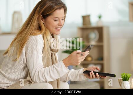 woman holding two remote controls Stock Photo