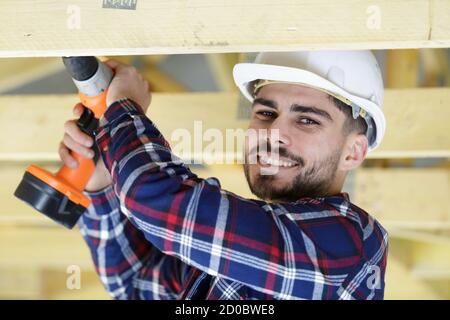happy man drilling hole in wood Stock Photo