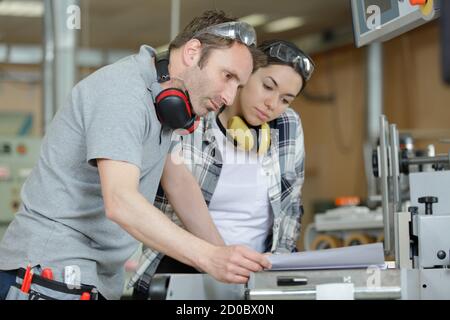 portrait of apprentice working with engineer on cnc machine Stock Photo