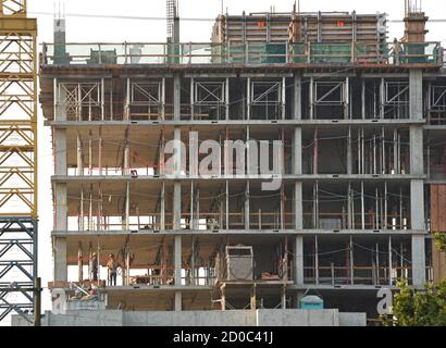 Workers stand in the concrete shell of of a condomnium housing apartment tower under construction in Victoria, British Columbia, Canada on Vancouver i Stock Photo