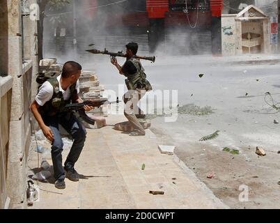 A Free Syrian Army Fighter Prepares To Fire A Rpg As A Syrian Army Tank Shell Hits A Building Across A Street During A Heavy Fighting In Salaheddine Neighborhood Of Central Aleppo