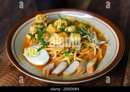 Curry noodle in a plate. Famous food called Mee Kari in malaysia. Noodle in a chicken curry gravy Stock Photo