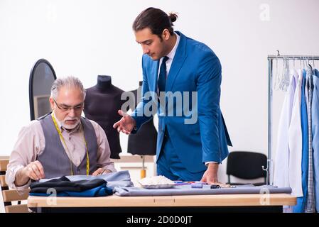 Young businessman visiting old tailor Stock Photo