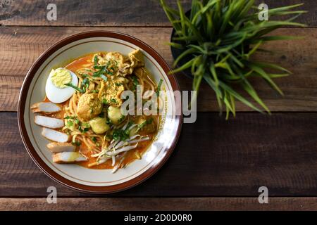 Curry noodle in a plate. Famous food called Mee Kari in malaysia. Noodle in a chicken curry gravy Stock Photo