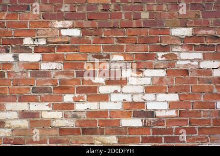 Weathered red and white brick wall background in abstract patterns. Stock Photo