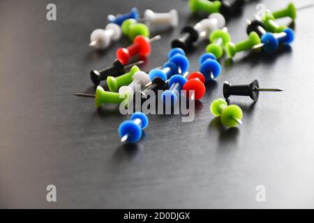 colorful punch pins drawing pins on black background Stock Photo