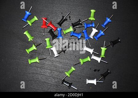colorful punch pins drawing pins on black background Stock Photo