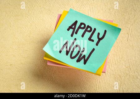 Apply now - handwriting on a reminder note, business marketing concept Stock Photo