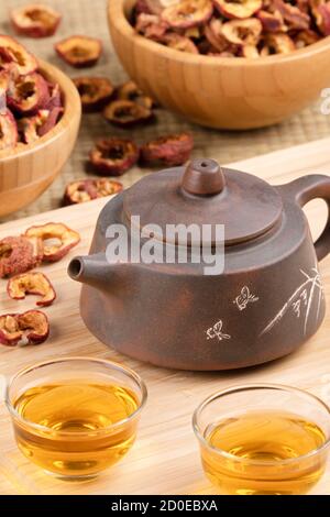 Close up of traditional Chinese tea pot and Hawthorn Fruit tea isolated on wooden background Stock Photo