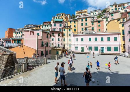 Riomaggiore, Italy. August 15, 2020: Square with people and children. Colorful houses in the small town of Riomaggiore in Liguria in Italy. Cinque Ter Stock Photo