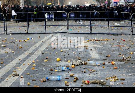 Garbage fills a street in front of police officers during riots in Skopje December 24, 2012. Government and opposition deputies brawled inside Macedonia's parliament and their supporters? hurled stones and bottles at each other outside on Monday in an escalating dispute over the proposed 2013 state budget. Thousands of pro- and anti-government demonstrators clashed in the centre of the capital Skopje outside parliament. Special police in riot gear intervened to separate the two groups, and local media said at least six people were hurt. REUTERS/Ognen Teofilovski (MACEDONIA  - Tags: CIVIL UNRES