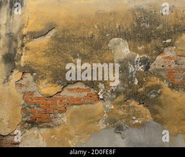 Old damaged brick wall with shabby plaster Stock Photo