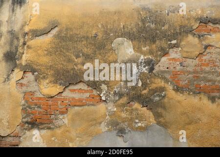 Old damaged brick wall with shabby plaster Stock Photo