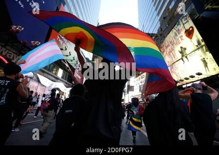 New York, United States. 02nd Oct, 2020. A protester holds a rainbow flag in support of transgender lives during the demonstration.Demonstrators gather in Times Square to demonstrate against the shooting of Roxanne Moore, a transgender woman. According to the Pennsylvania police, Moore a mentally ill woman, was shot 16 times while brandishing a gun in public. Credit: SOPA Images Limited/Alamy Live News