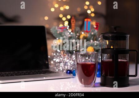 Laptop with black screen next to french press and tea near new years decorations. christmas theme template. Stock Photo