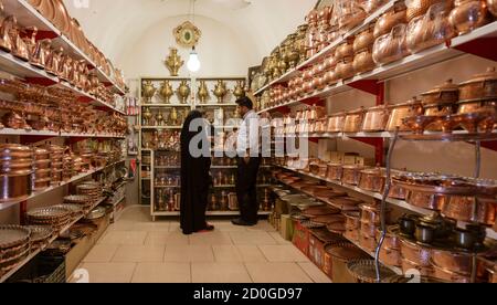 Yazd, Iran - 2019-04-11 - Customer shops in a copper ware vendor shop. Stock Photo