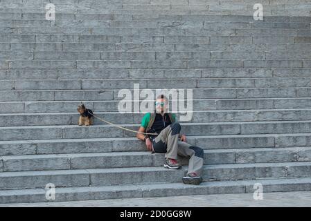 BARCELONA, CATALONIA, SPAIN - OCTOBER 02, 2016.  The man with the dog on the stairs near the church of Temple Expiatori del Sagrat Cor (by Josep Miret Stock Photo