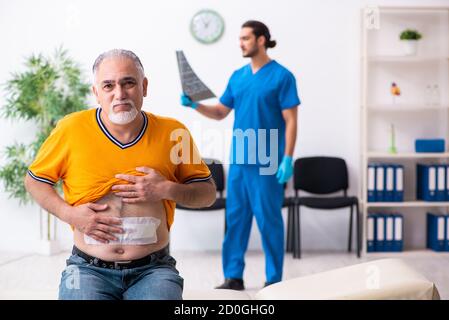 Old man visiting male doctor Stock Photo