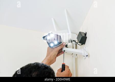 Technicians are installing wireless CCTV cameras on the walls of the house for security purposes. Stock Photo
