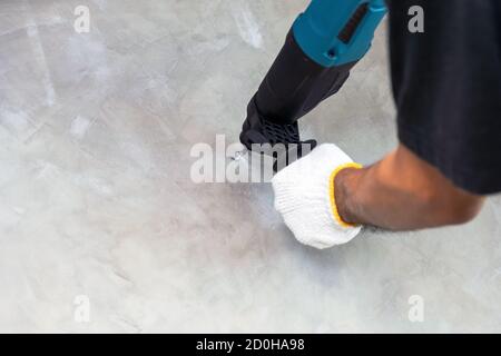 Construction workers are using an electric drill to drill holes in concrete walls. Stock Photo
