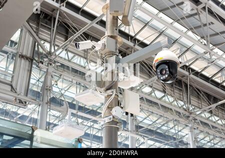 CCTV cameras, wireless signal distribution equipment and speakers mounted on poles inside the building. Stock Photo