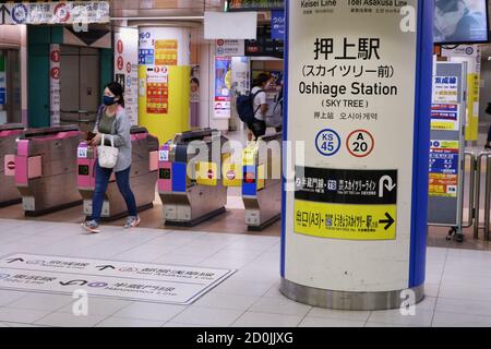 People using ticket gates at Oshiage Station near Tokyo Skytree. Some motion blur. People wear face masks during coronavirus outbreak. (Oct. 2020) Stock Photo