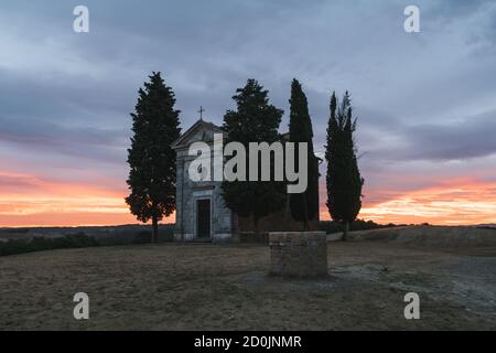 Chapel Capella della Madonna di Vitaleta in Val d' Orcia, Tuscany, Italy at Sunrise or Dawn in the Romantic and Mysterious First Light in the Early Mo Stock Photo