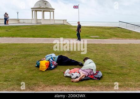 Two People Sleeping/Resting On The Lawns At Bexhill On Sea, East Sussex, UK. Stock Photo
