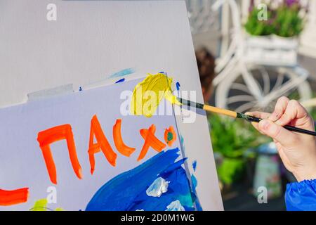 Open air workshop.  Easter Holiday festival in Moscow. A child paintis a picture for Easter. Easter inscription in Russian Stock Photo
