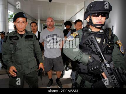 Thai policemen escort American drug suspect Joseph Hunter, 48, at Don Mueang International Airport in Bangkok September 27, 2013. Thai police transferred six foreigners suspected of drug smuggling to Bangkok on Thursday after their arrests in the seaside resort, Phuket. Hunter, along with two British, a Taiwanese, a Slovak, and a Filipino were arrested on Phuket island on Wednesday following a tip-off from the United States Drug Enforcement Administration (DEA).   REUTERS/Chaiwat Subprasom (THAILAND - Tags: CRIME LAW DRUGS SOCIETY)
