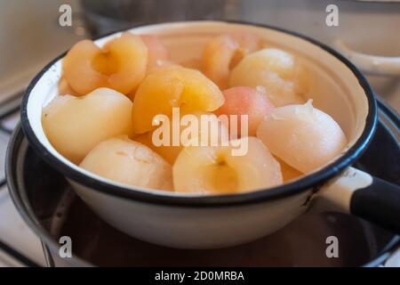 freshly boiled peeled hot apples in colander Stock Photo